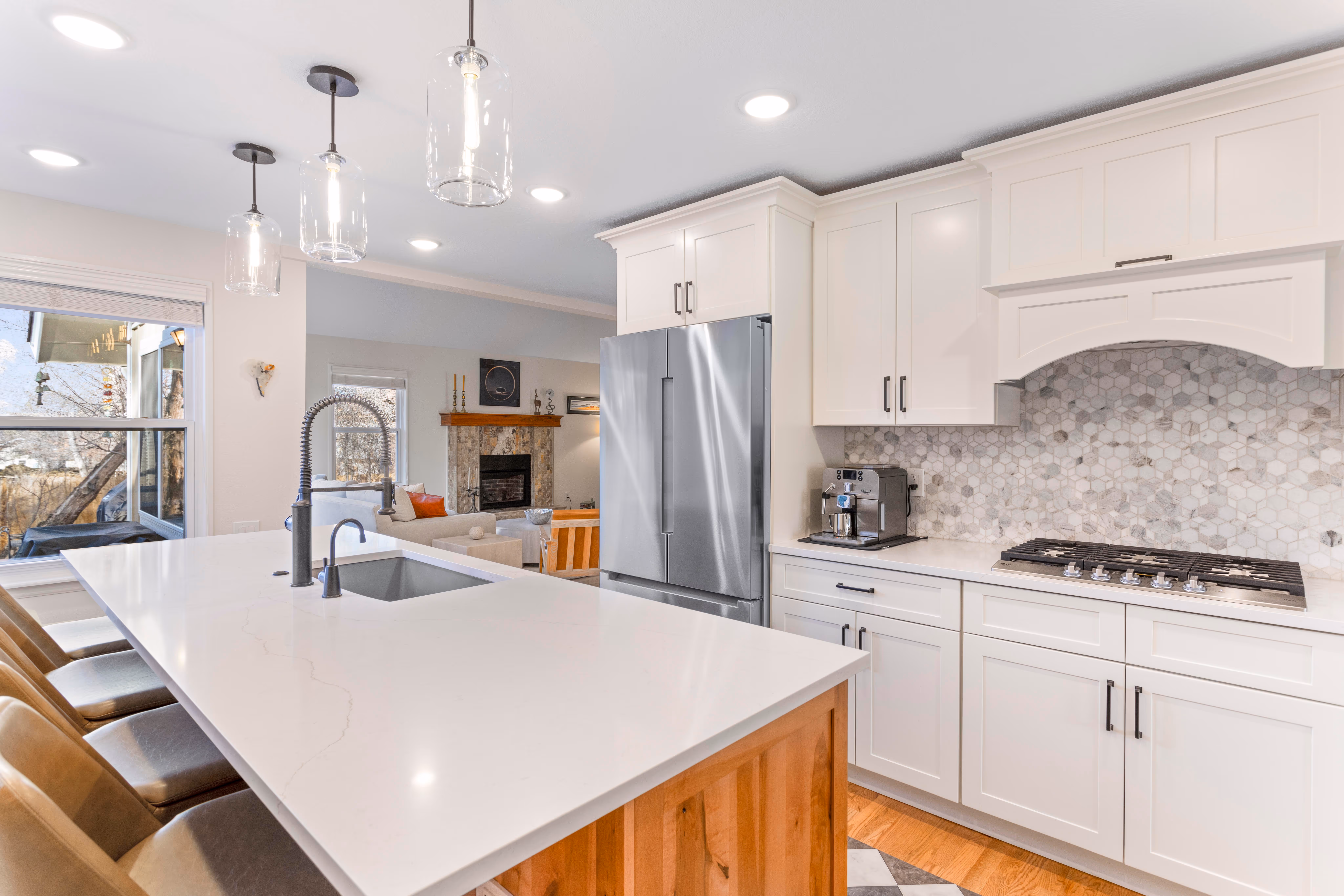 Homeowner smiling in their newly renovated kitchen with beautifully refinished cabinets.