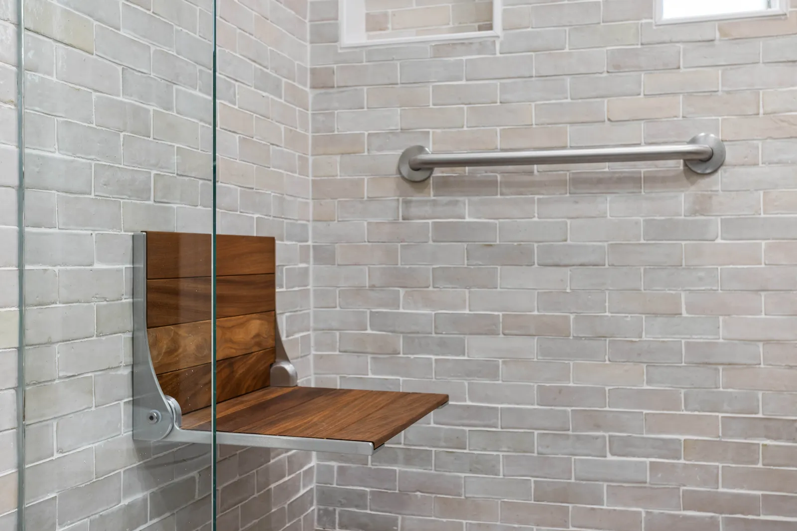 Teak fold-down shower bench in a Centennial aging-in-place remodel