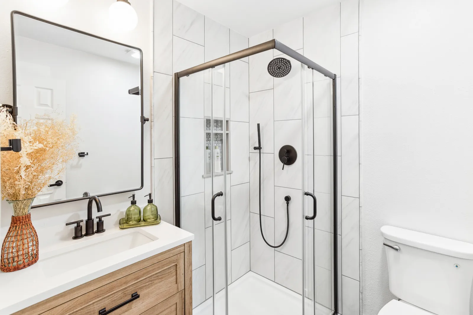 Guest bath with round mirror and black fixtures, Englewood CO