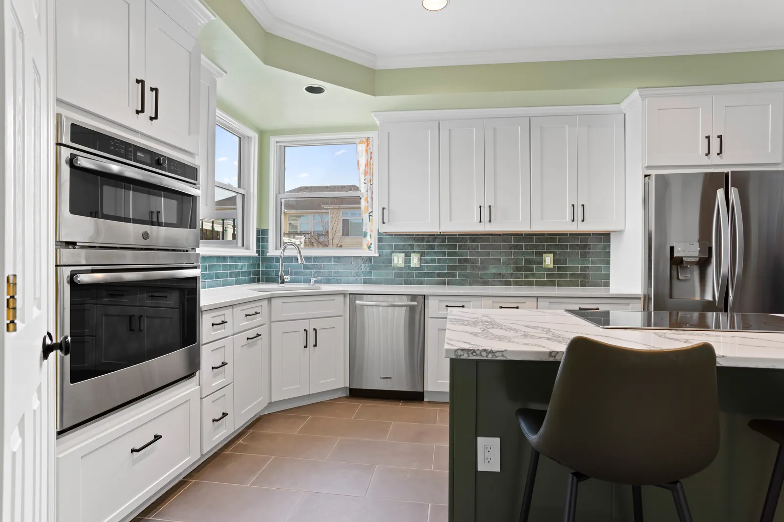 Stainless range with teal backsplash in a remodeled Highlands Ranch kitchen