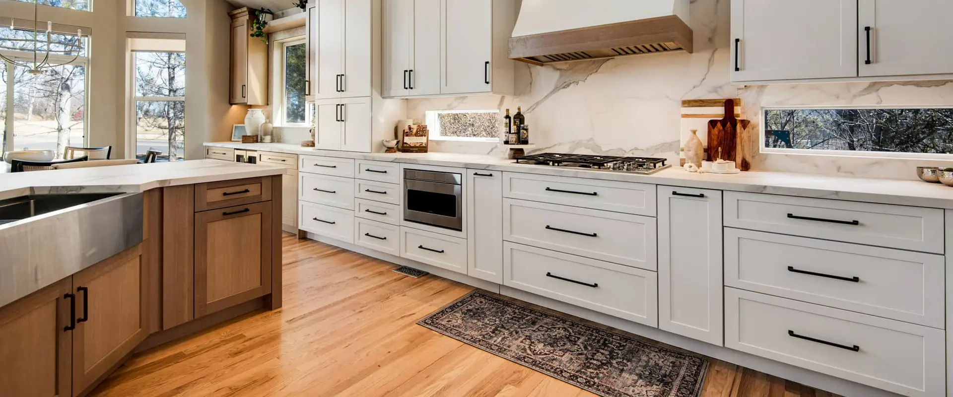 Completed kitchen remodel with a large island, warm wood flooring, and open sightlines