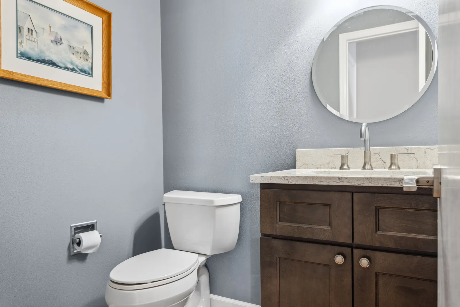 Remodeled powder room with wood vanity and round mirror, Denver Tech Center