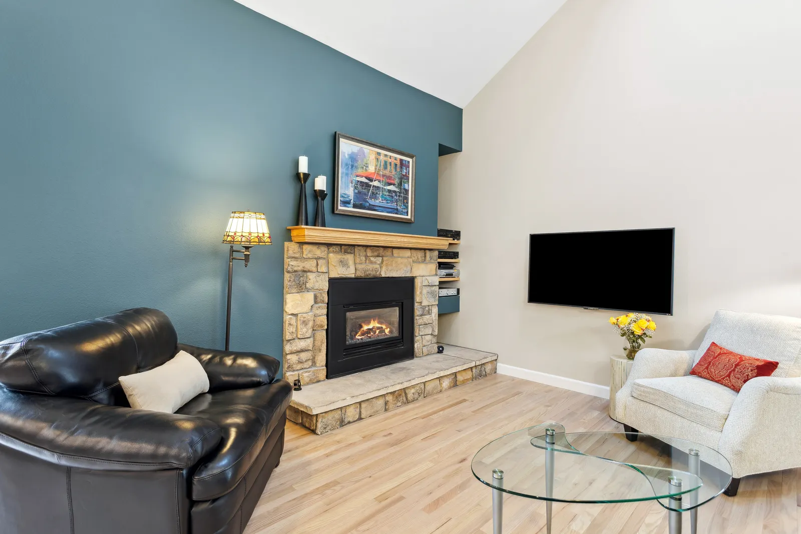 Living room with stone fireplace and teal accent wall, Denver remodel